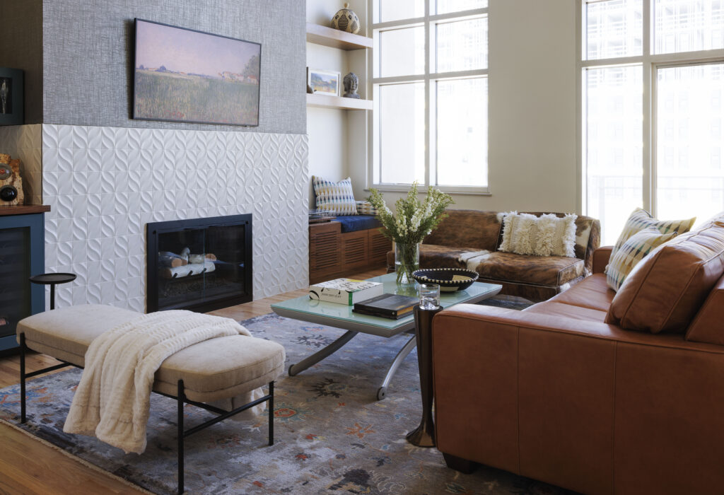 Golden Triangle Hi-Rise living room with leather sectional and textured fireplace surround — company kd